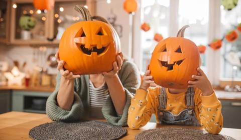 Adult and child holding carved pumpkins