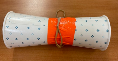 Two paper cups taped together at the bottom with a rubber band chain wrapped around the center