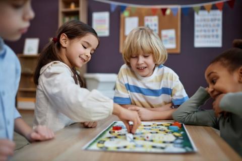 four children playing a board game