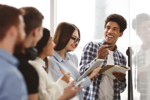 group of young people working together at a whiteboard