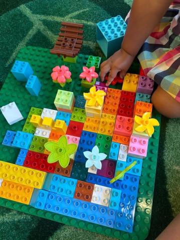 Preschooler hands building with Duplo building blocks.