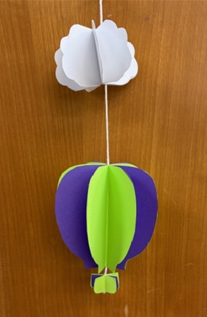 Three-dimensional paper hot air balloon and cloud hanging from a string