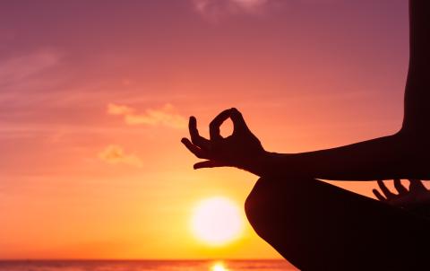 sunset with person meditating in lotus position