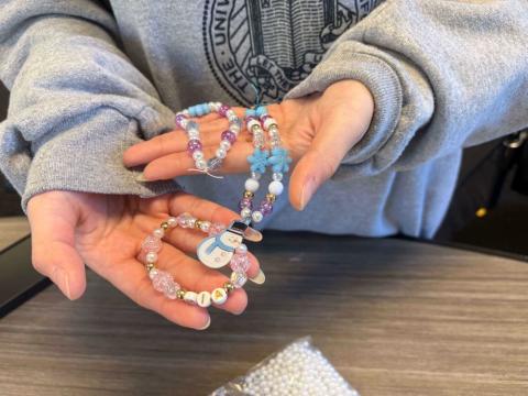 A person with a couple beaded bracelets in her palms.