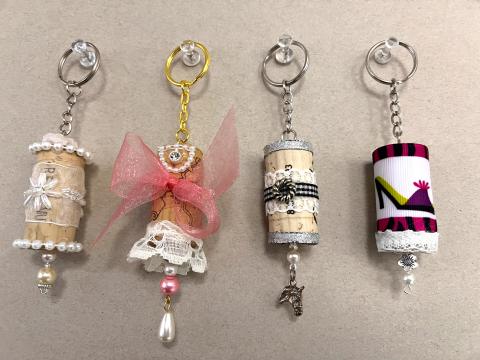 four keychains made with a cork and decorations and charms