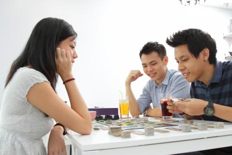 Three adults playing a board game