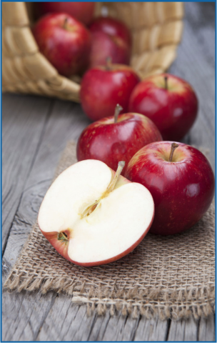 Basket of red apples, one sliced in half