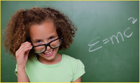 Girl next to blackboard wearing glasses