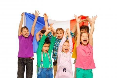 Group of kids holding the French flag behind them