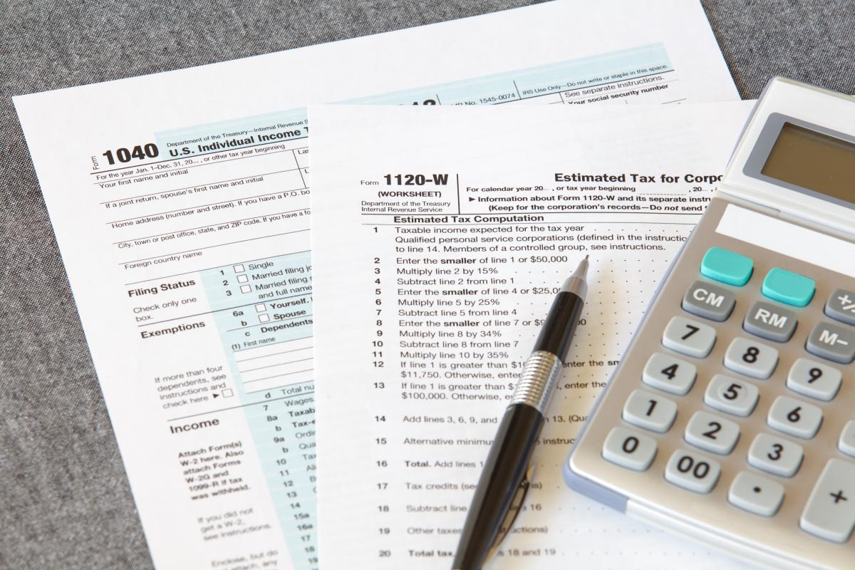 Tax forms, pencil and calculator.