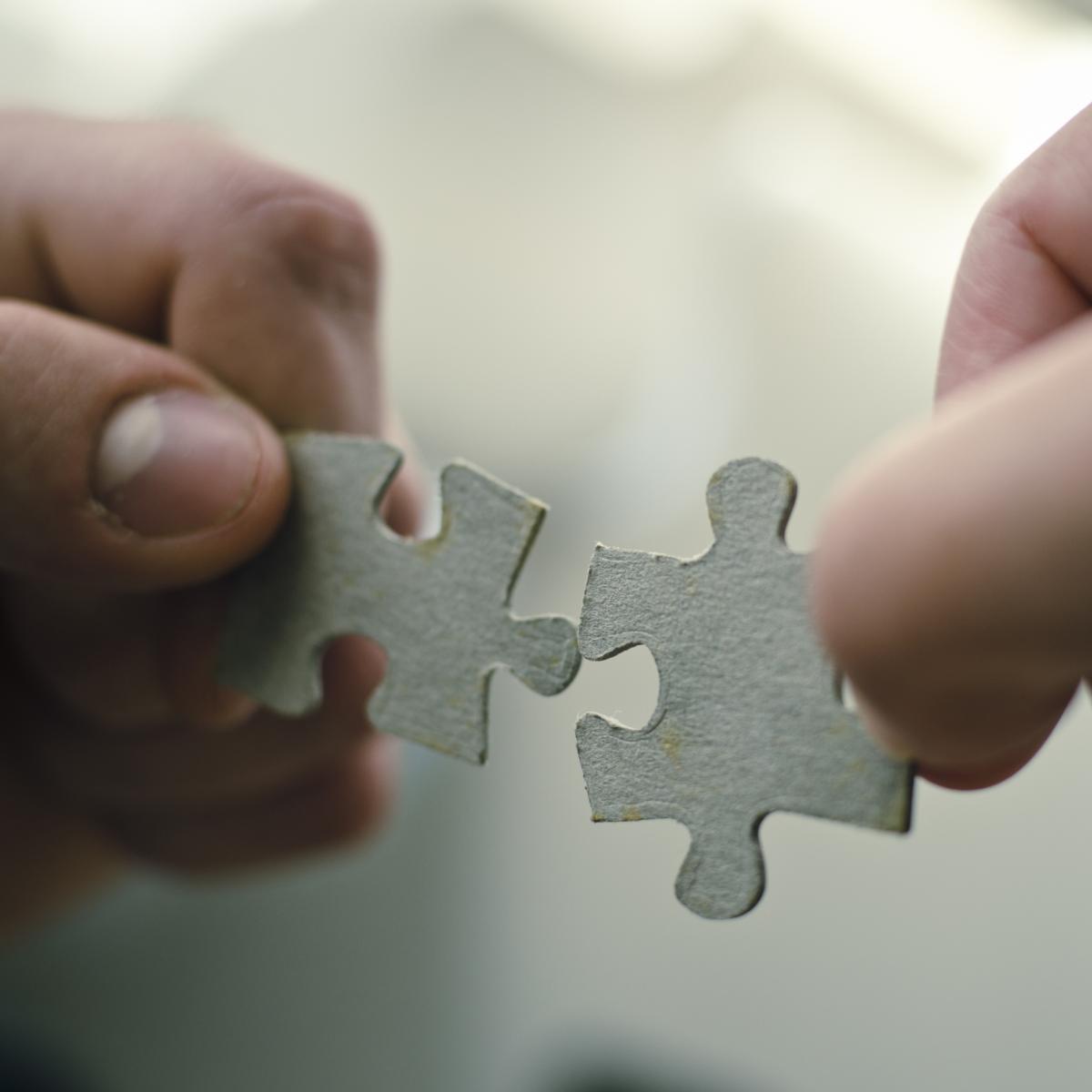 two jigsaw puzzle pieces being joined together