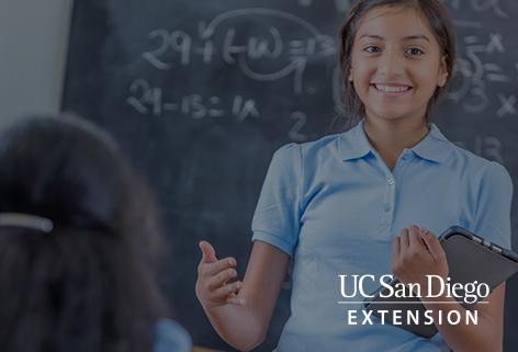 Girl with tablet standing in front of a classroom