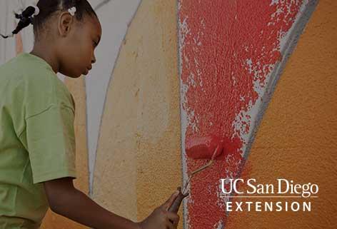 Girl painting a red triangle on a wall