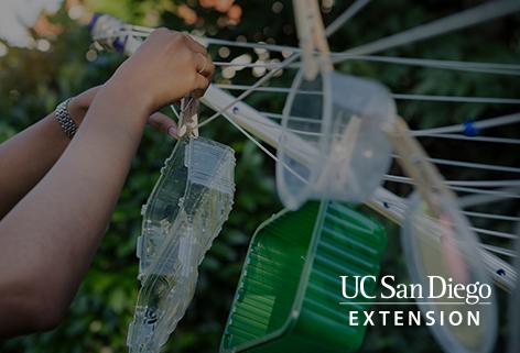 Girl hanging recycled plastic containers on clothes line