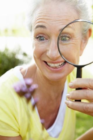 Person looking through magnifying glass.