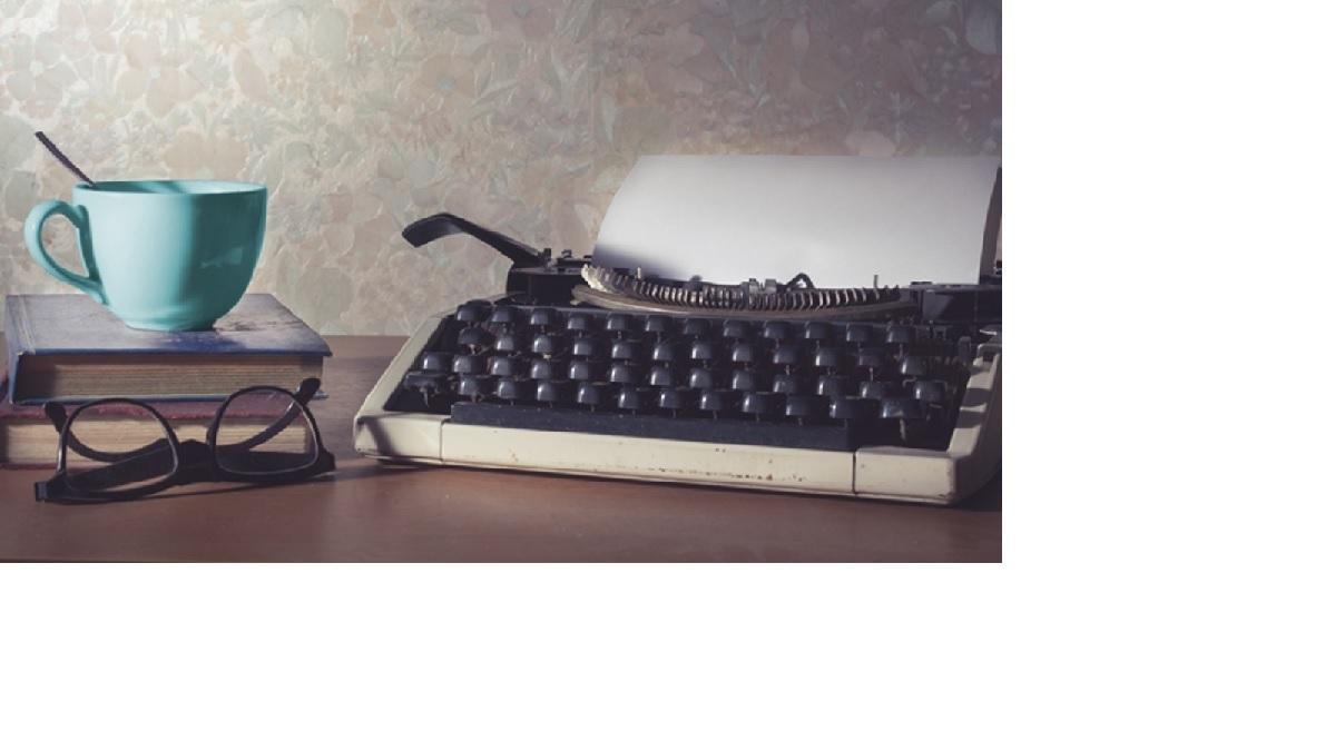 logo showing typewrter and coffee mug on a desk.