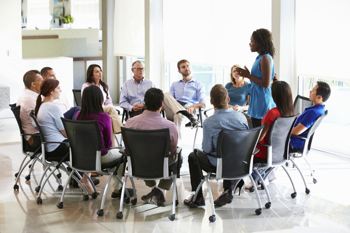 Group of seated adults in a circle having a discussion