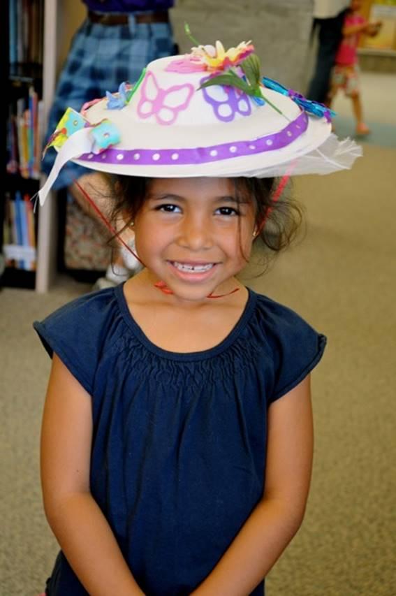 Little girl smiling at the camera wearing a DIY hat