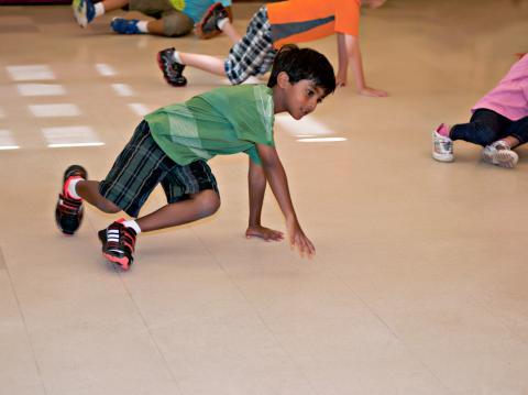 A Boy Dancing with other children in the background