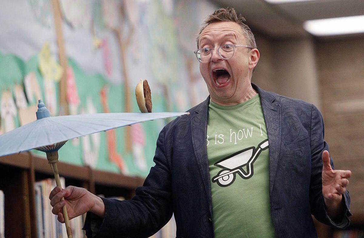 photo of Michael Rayner holding a parasol and spinning a cheeseburger on top