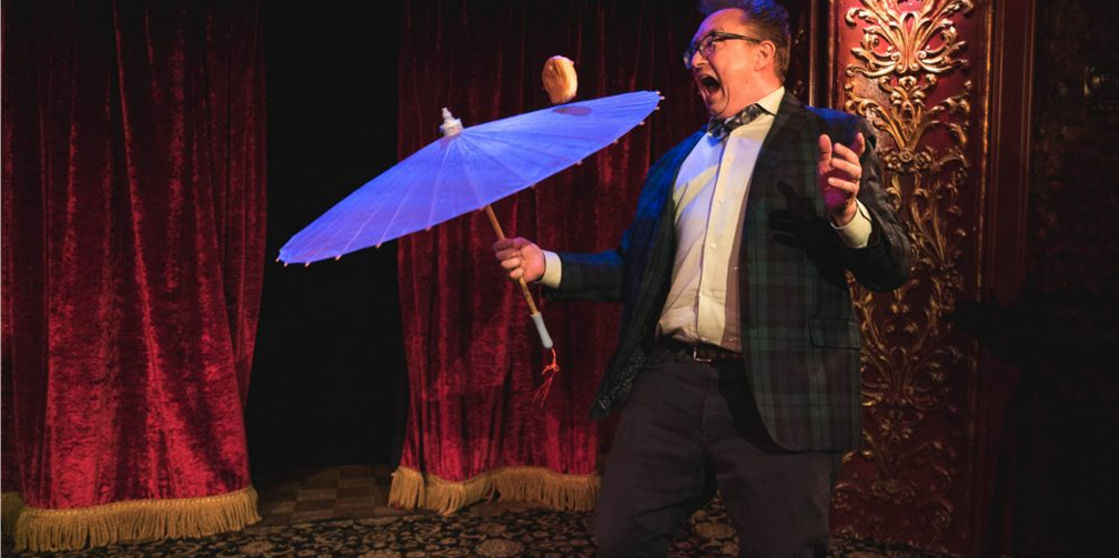 man spinning a blue umbrella