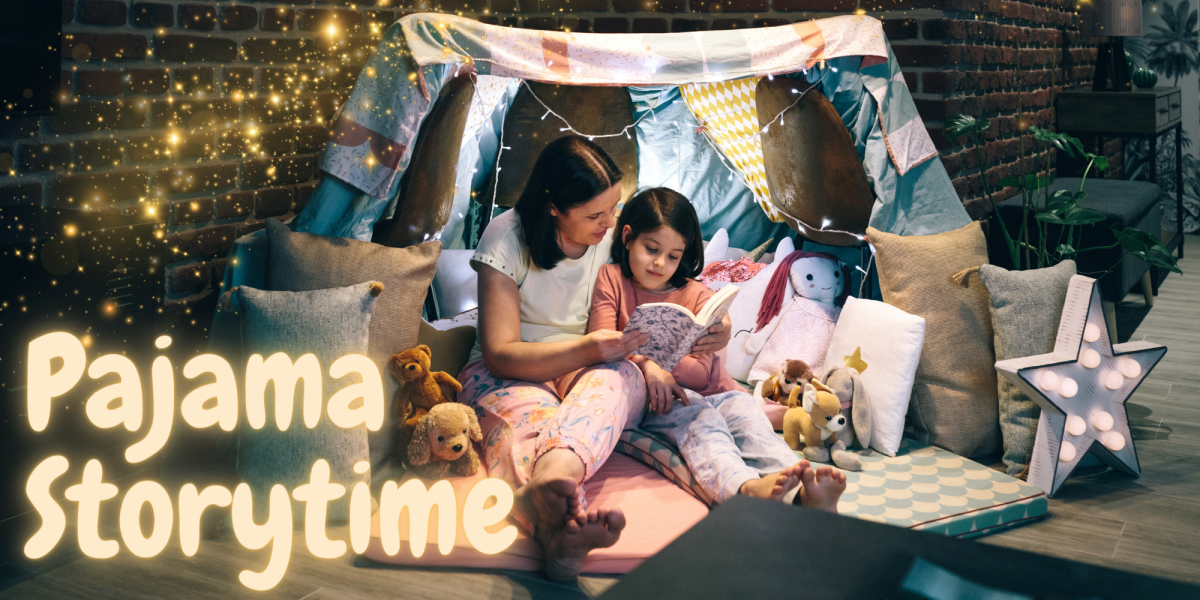 Young girl and adult woman reading together under a blanket tent