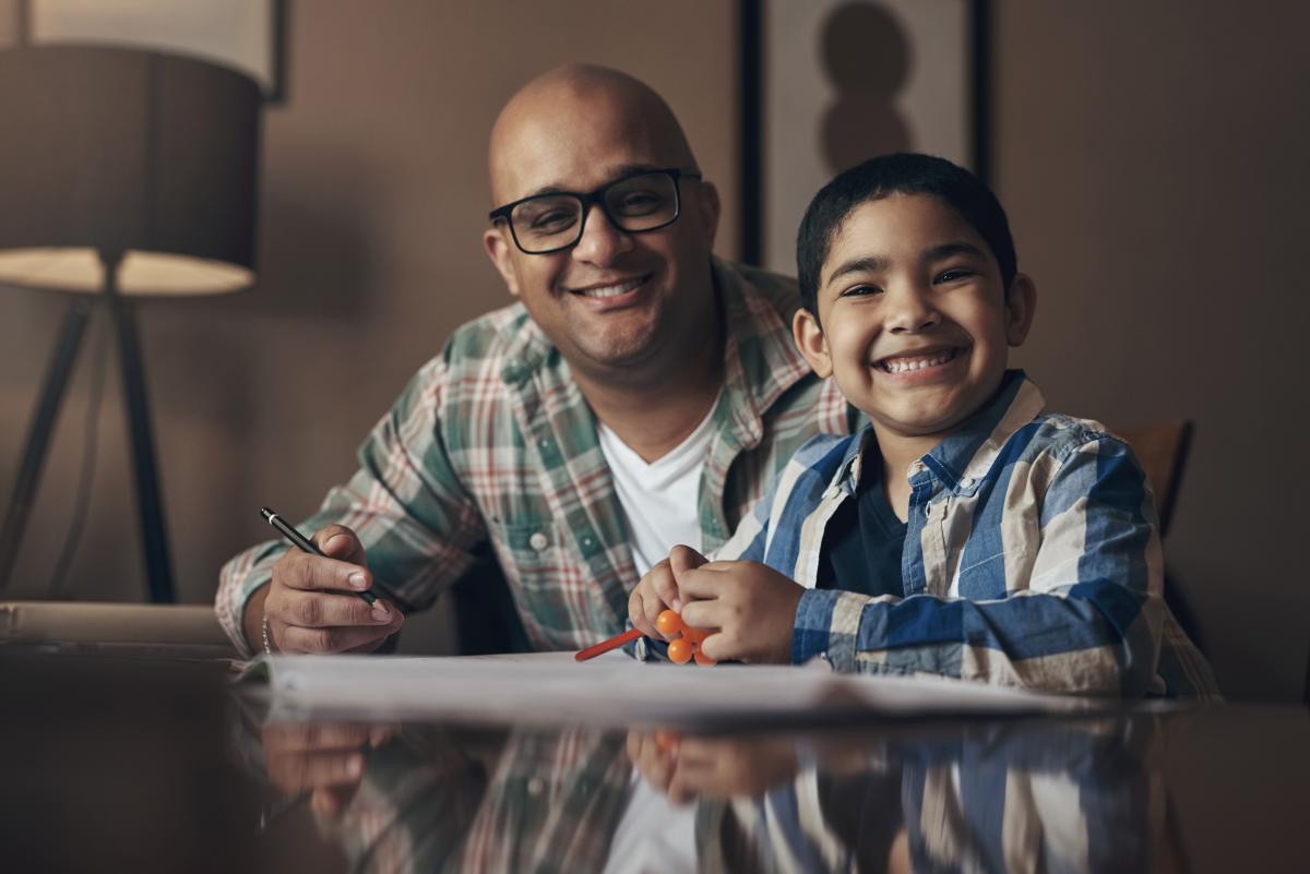 Father and son learning together at a table at home