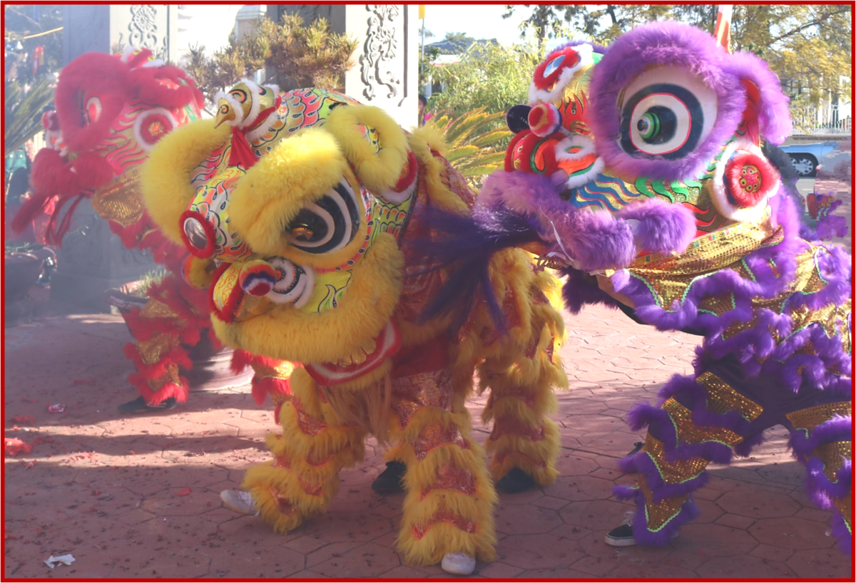 Red, yellow, and purple lions performing traditional dance