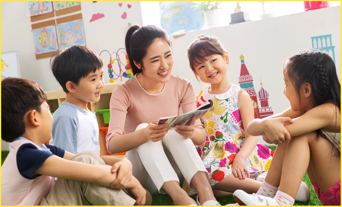 Chinese woman reading to four smiling Chinese children.