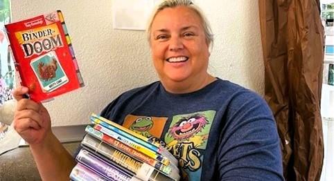 Learn about the library with Ms. Maureen, pictured, holding her favorite summer reads