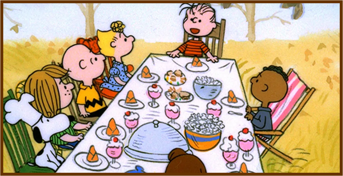 Charlie Brown and friends sitting at table for Thanksgiving meal in the park