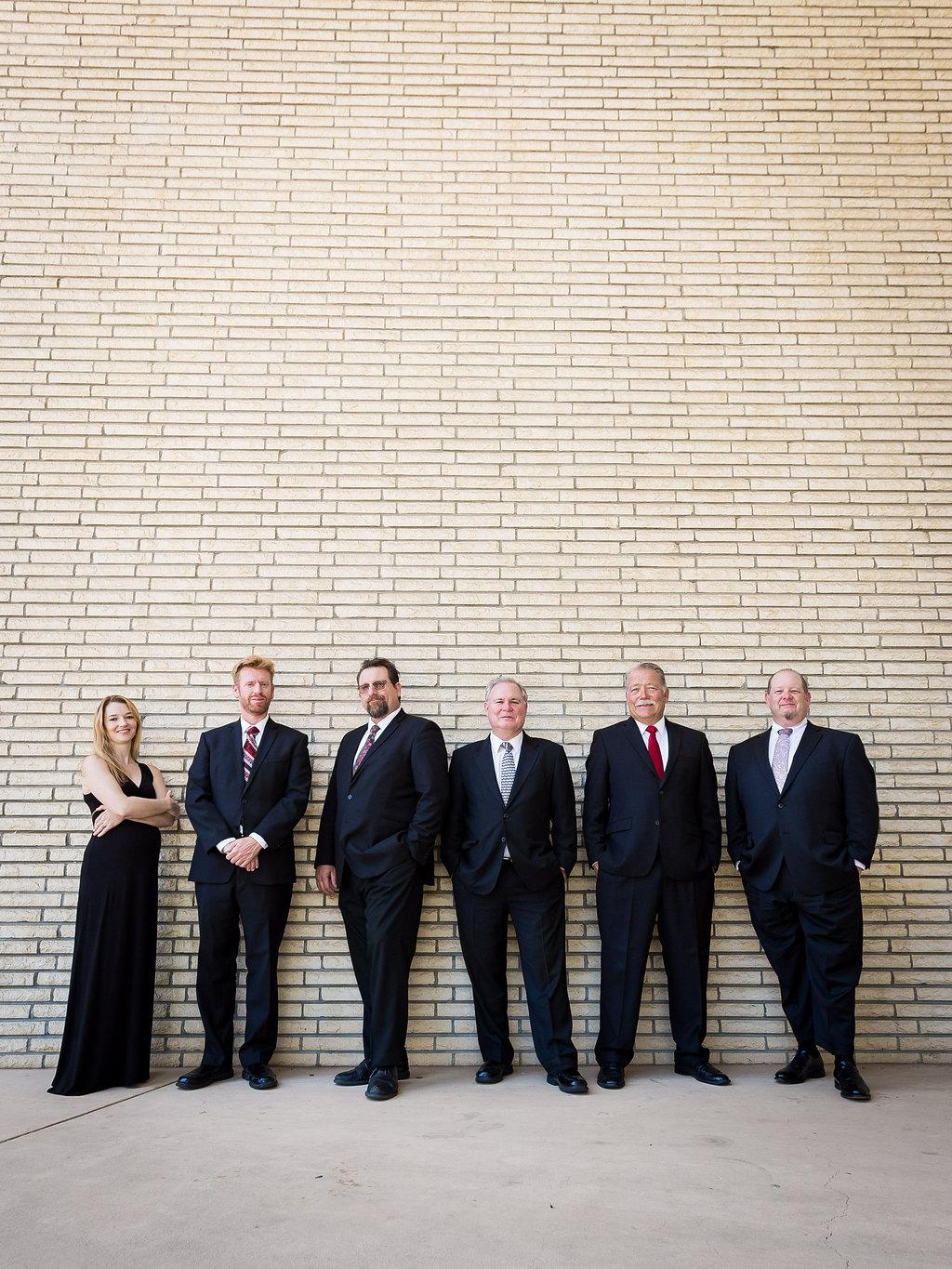 Image of Westwind Brass members standing in a line wearing black