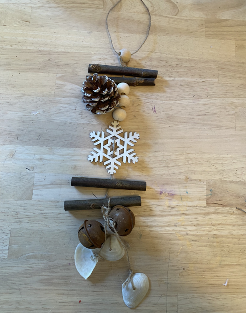 mobile with pinecones, wood sticks, shells and a snowflake