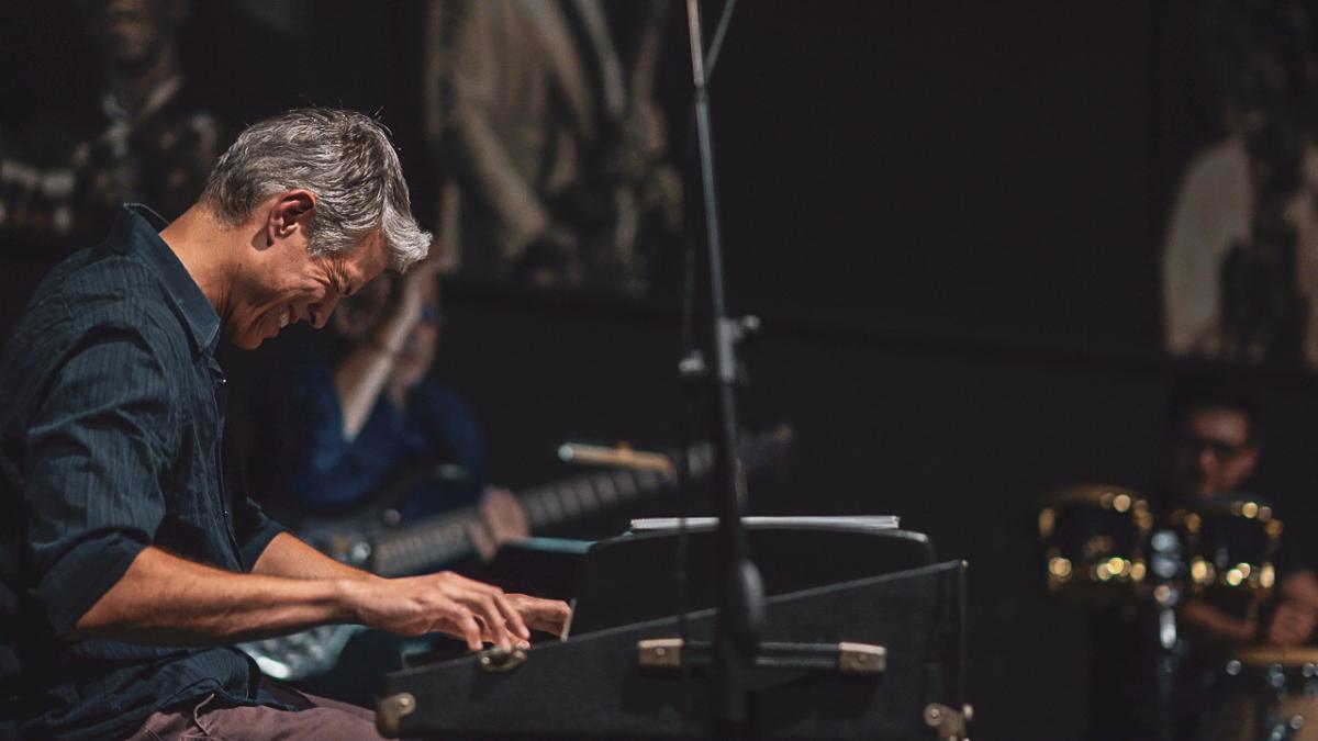 Photo of a man smiling while playing keyboards