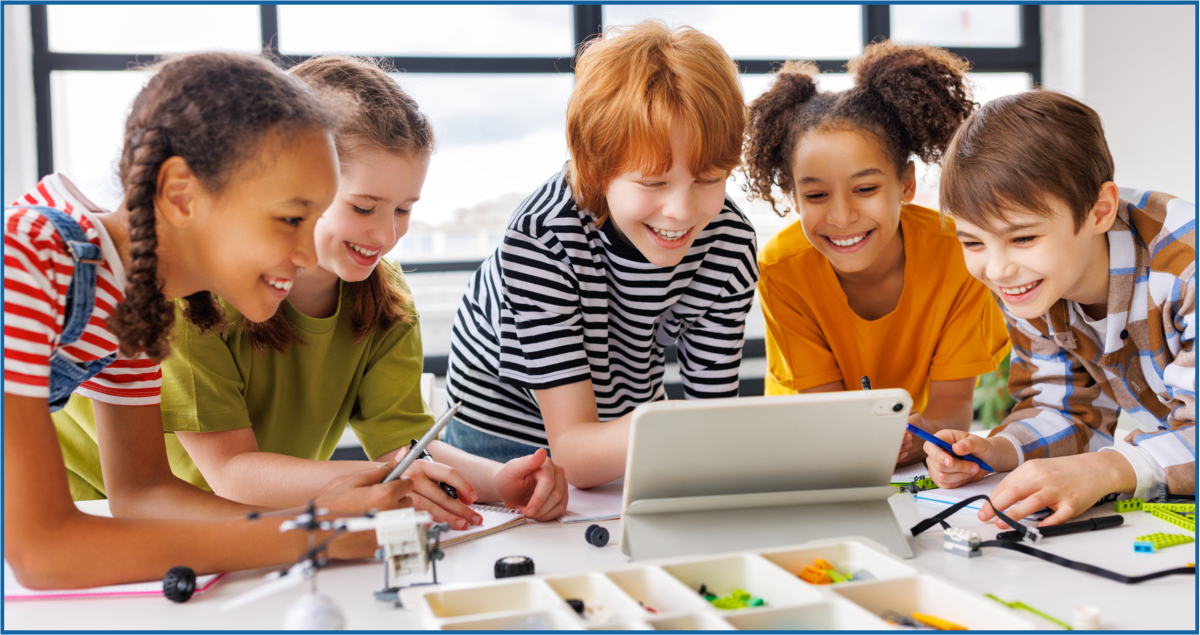 Five children gathered around a laptop and craft items on a table