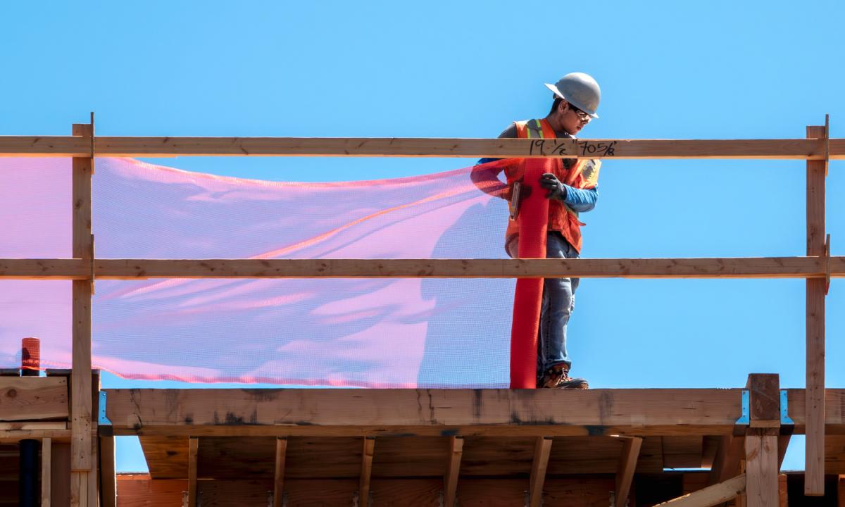 Construction worker on wood platform.