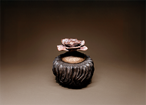 Ceramic art of a brown flower. Artist Monica Miller