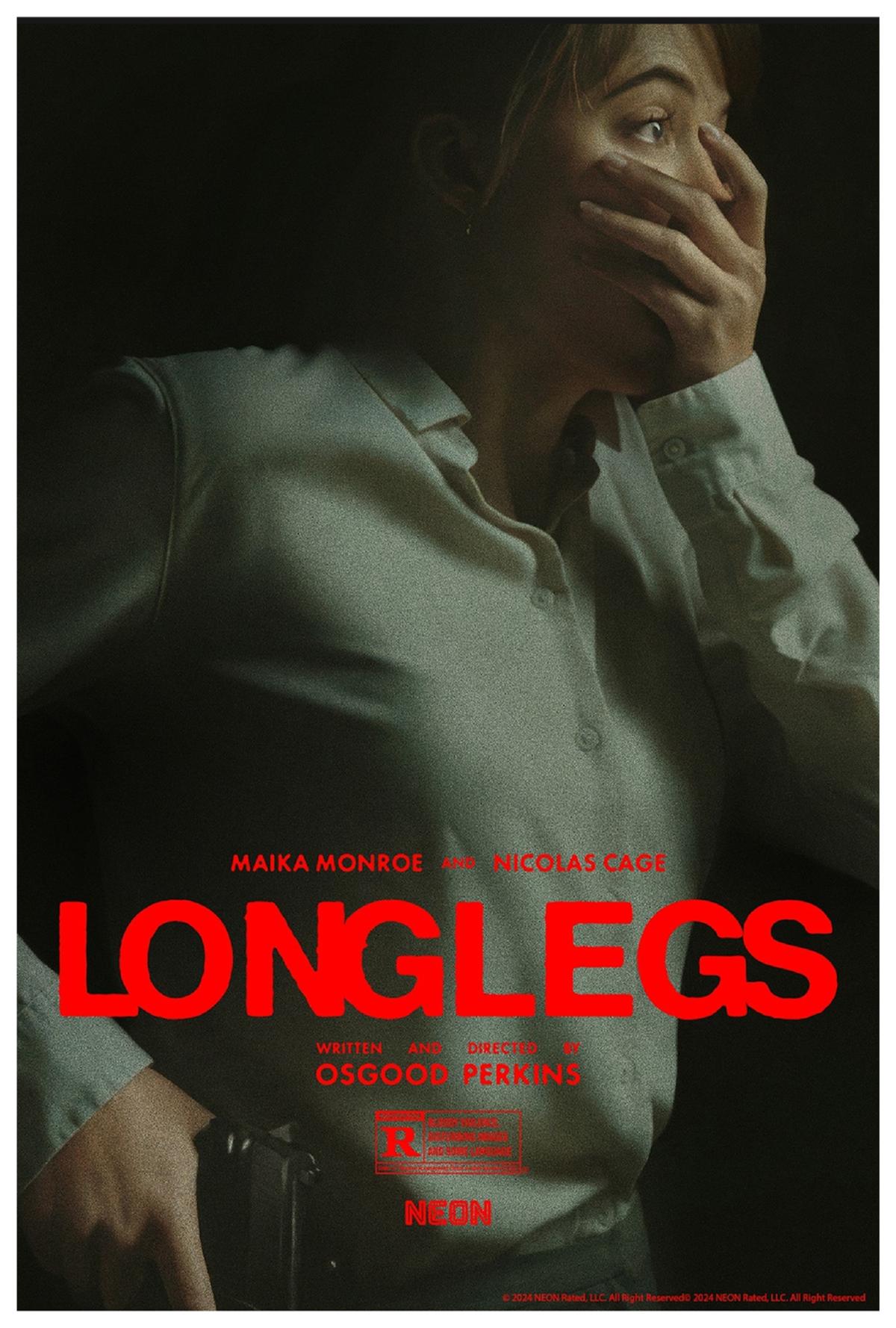 Photograph of a woman, one hand covering her mouth, and the other, holding a gun.