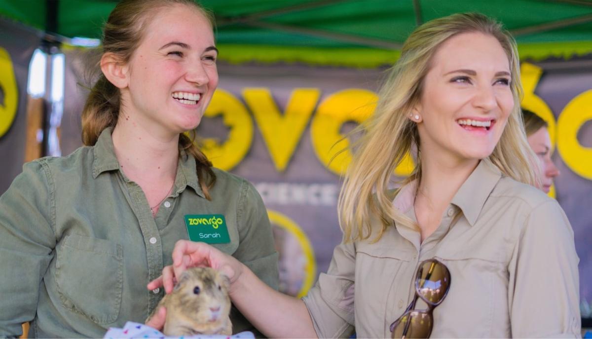 Two women holding a guinea pig