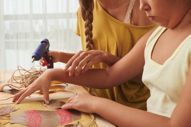 Girls work on a craft on a table.